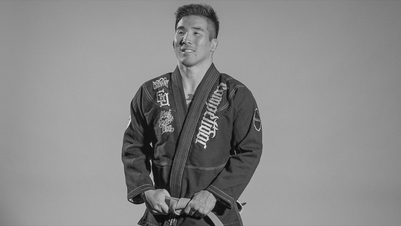 Tim Hirata in a jiu-jitsu gi, holding his black belt