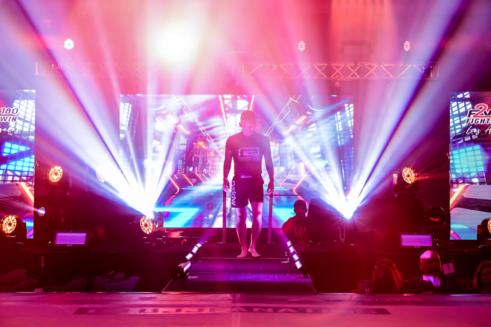 Tim Hirata walking out onto a lit stage at a jiu-jitsu event